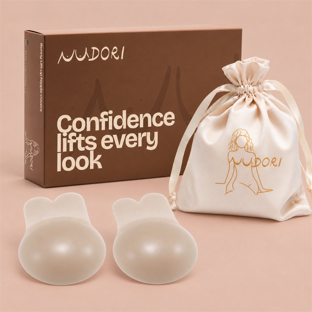 Nudori Bunny Lift-Up Nipple Covers in Beige with the Nudori box and satin pouch on a nude studio background.