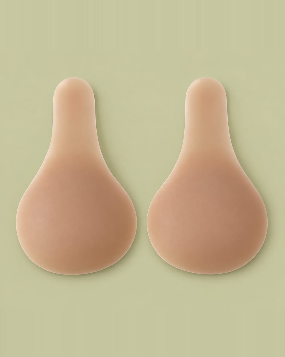A pair of Nudori Long-Strap Lift-Up Nipple Covers laid flat on sage, each teardrop cup tapering into a long rounded lift strap.
