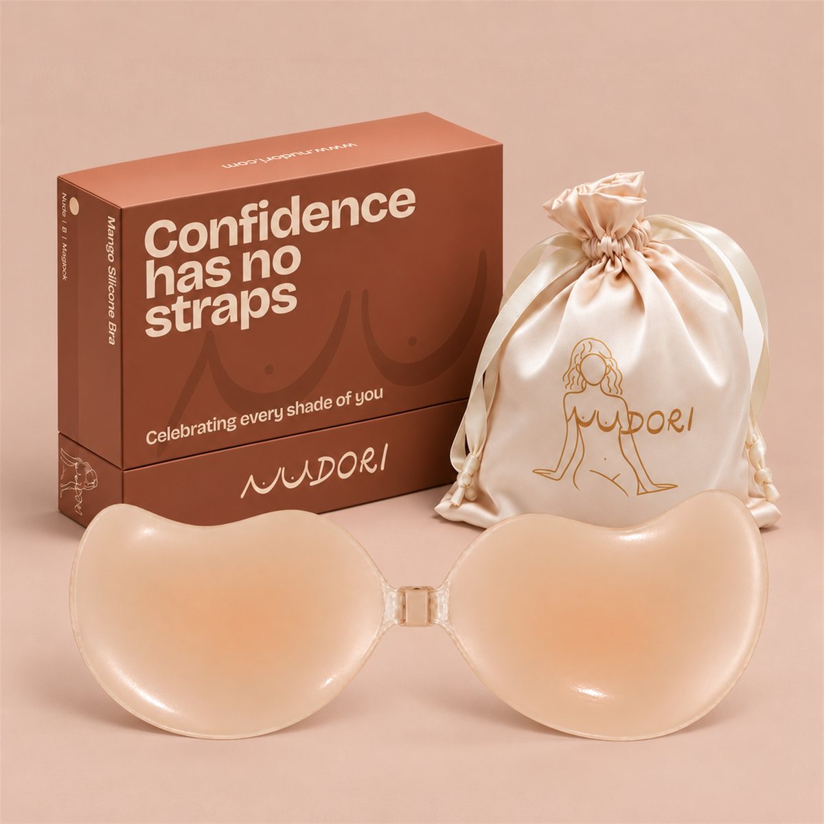 Nudori Mango Silicone Bra in Nude with the MagLock front clasp, box and satin pouch on a nude studio background.