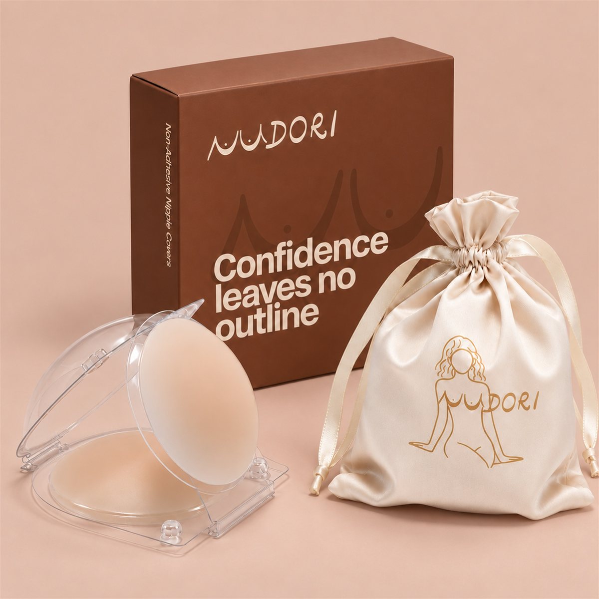 Nudori Non-Adhesive Nipple Covers in Skin+ in the clear storage dome, with the Nudori box and satin pouch on a nude studio background.