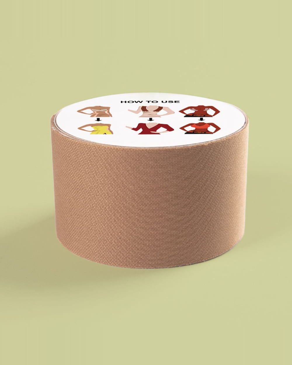 A roll of Nudori Boob Tape standing upright on sage, the how-to-use diagram printed across the top of the roll.