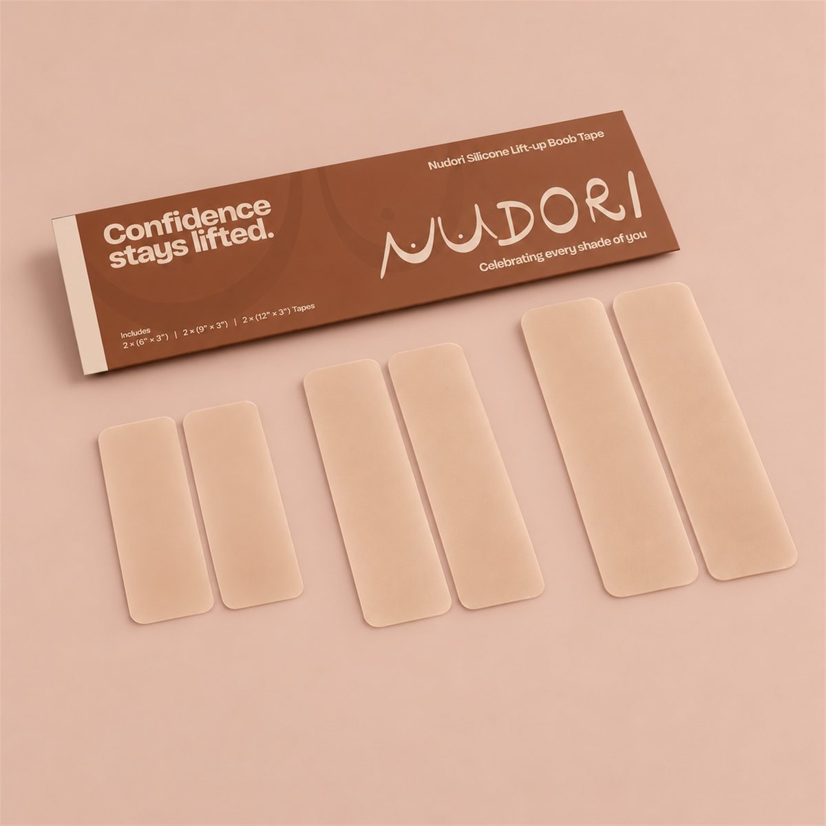 Nudori Silicone Lift-Up Boob Tape in Beige: six pre-cut strips in three lengths with the box, on a nude studio background.